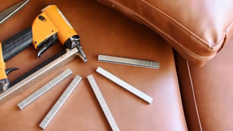 pan left-upholstery tools on a vinyl sofa and ocher cushions