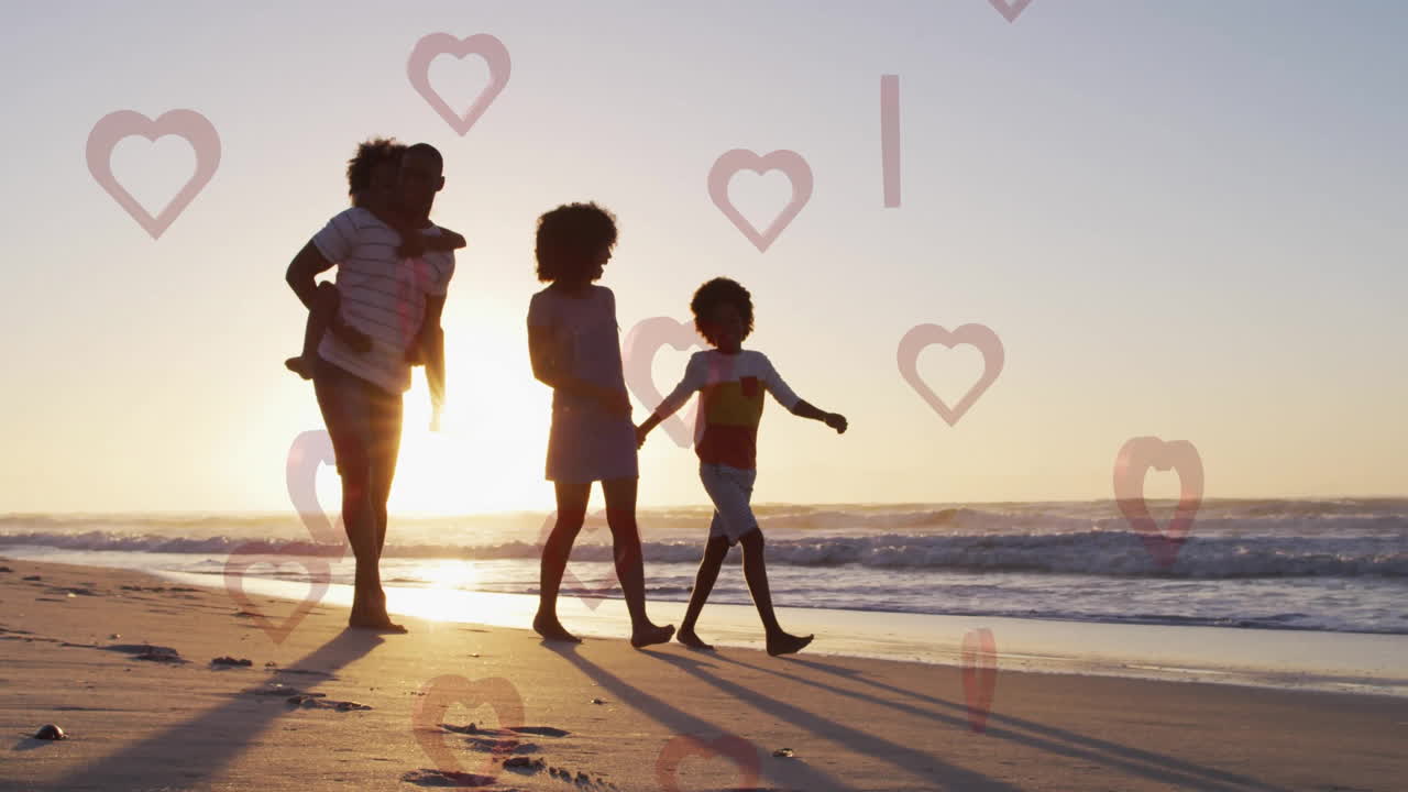 Family walking on beach at sunset with heart shapes overlay animation