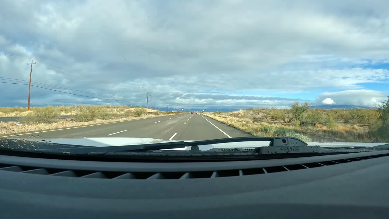 Punto di vista - Guidando su un'autostrada tranquilla attraverso la rurale Valle di Rincon del Deserto di Sonora in una giornata nuvolosa nell'Arizona meridionale