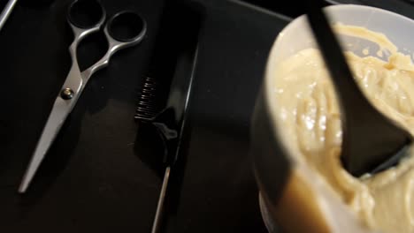 peine, tijeras y tinte para el cabello en un cuenco en una bandeja