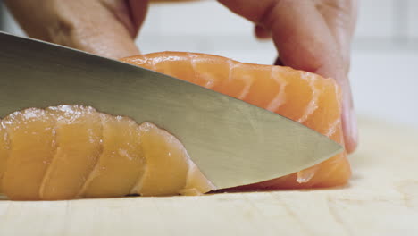 raw salmon being sliced for use in sushi and sashimi