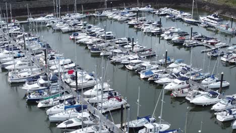 Scenic-luxurious-waterfront-harbour-apartment-village-yachts-and-sailboats-under-mountain-coastline-aerial-Birdseye-orbit-right-view