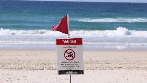 danger sign on beach with red flag