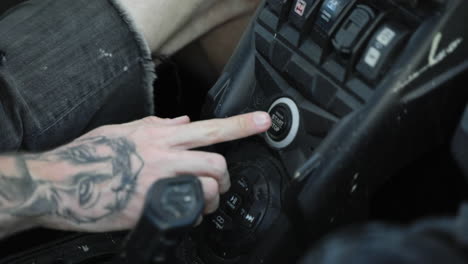 Tattooed-Male-Hand-Pushing-Ignition-Button-On-Dirt-Buggy