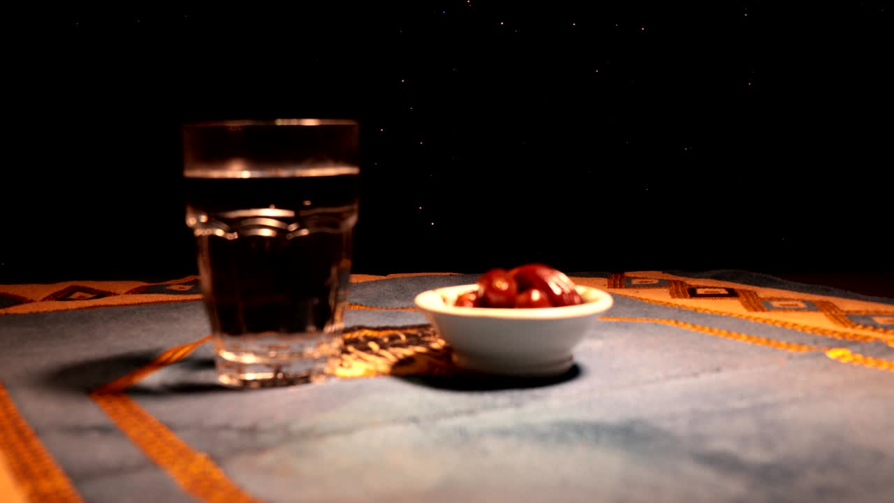 agua y dátiles. el iftar es la comida de la noche. vista deslizante de la decoración vacaciones de ramadán kareem. tarjeta de felicitación festiva, invitación para el mes sagrado musulmán ramadán kareem. fondo oscuro. enfoque selectivo