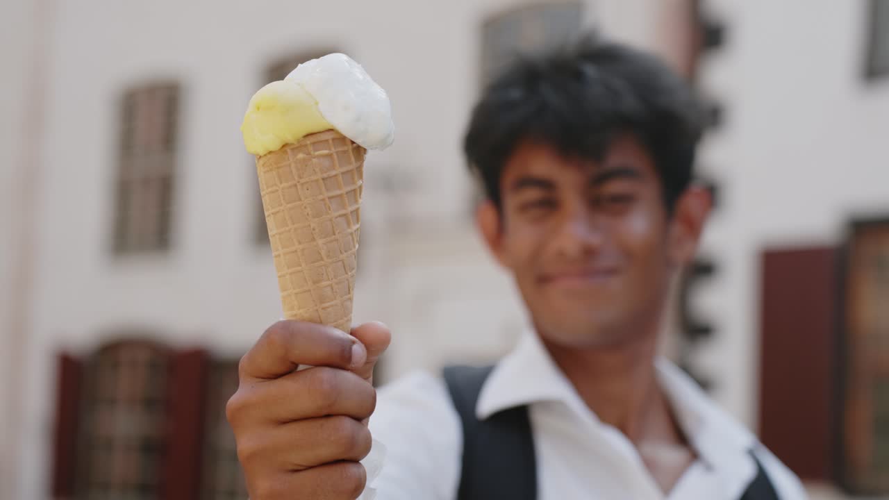 Primo piano di gelato, giovane uomo eccitato e sfocato che tiene un cono, panoramica circolare
