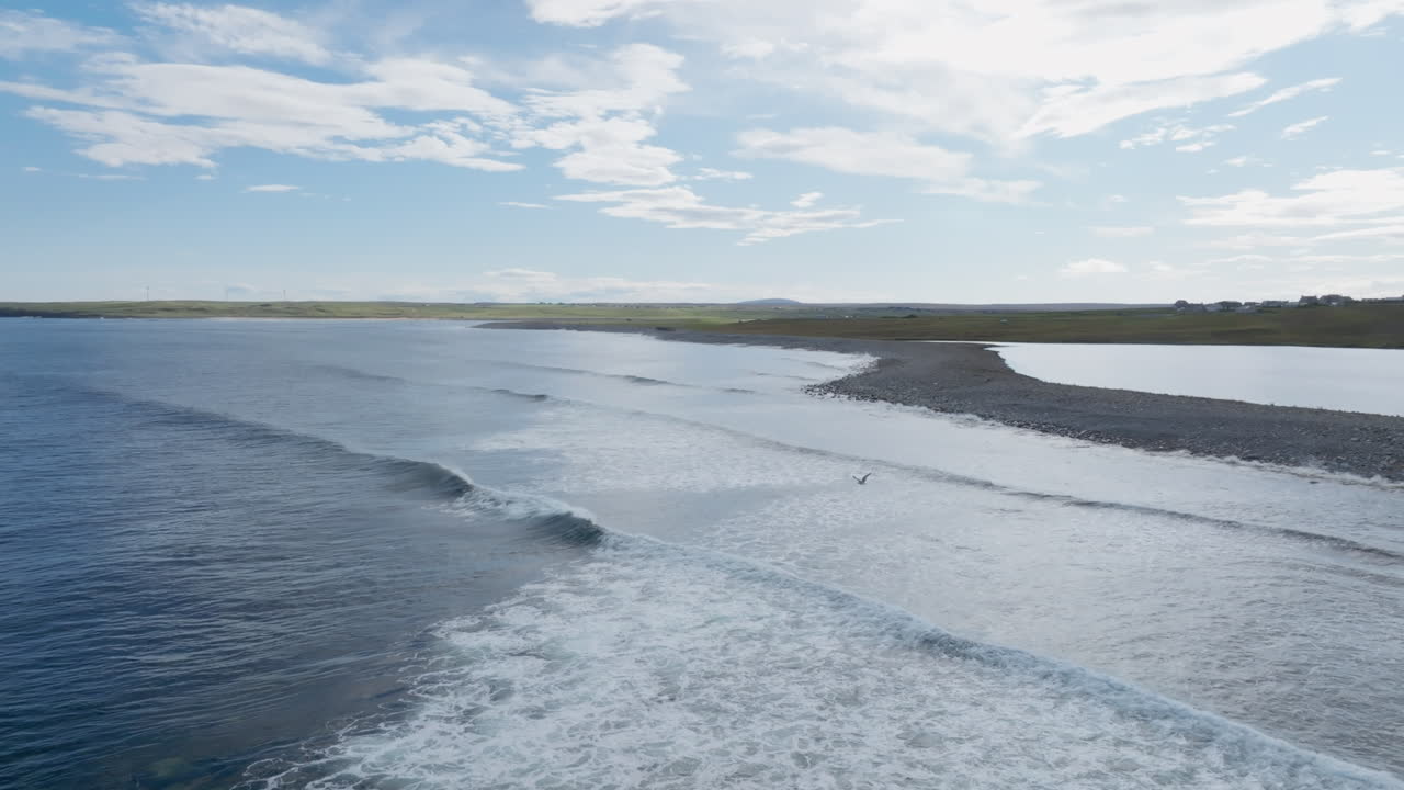 Aerial drone footage of Barvas Beach on the Isle of Lewis, where Loch Mor Bharabhais meets the Atlantic. Clean swell lines and bright skies capture the wild coastal beauty of the Outer Hebrides