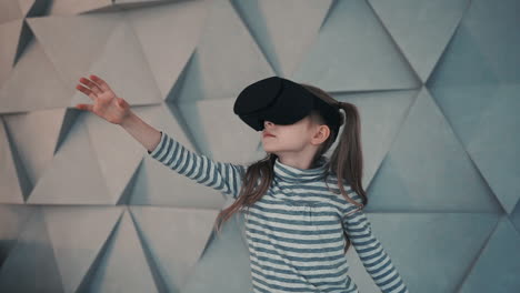 Niña-Pequeña-Con-Gafas-De-Realidad-Virtual-Disfrutando-De-Un-Video-O-Juego-Interactivo