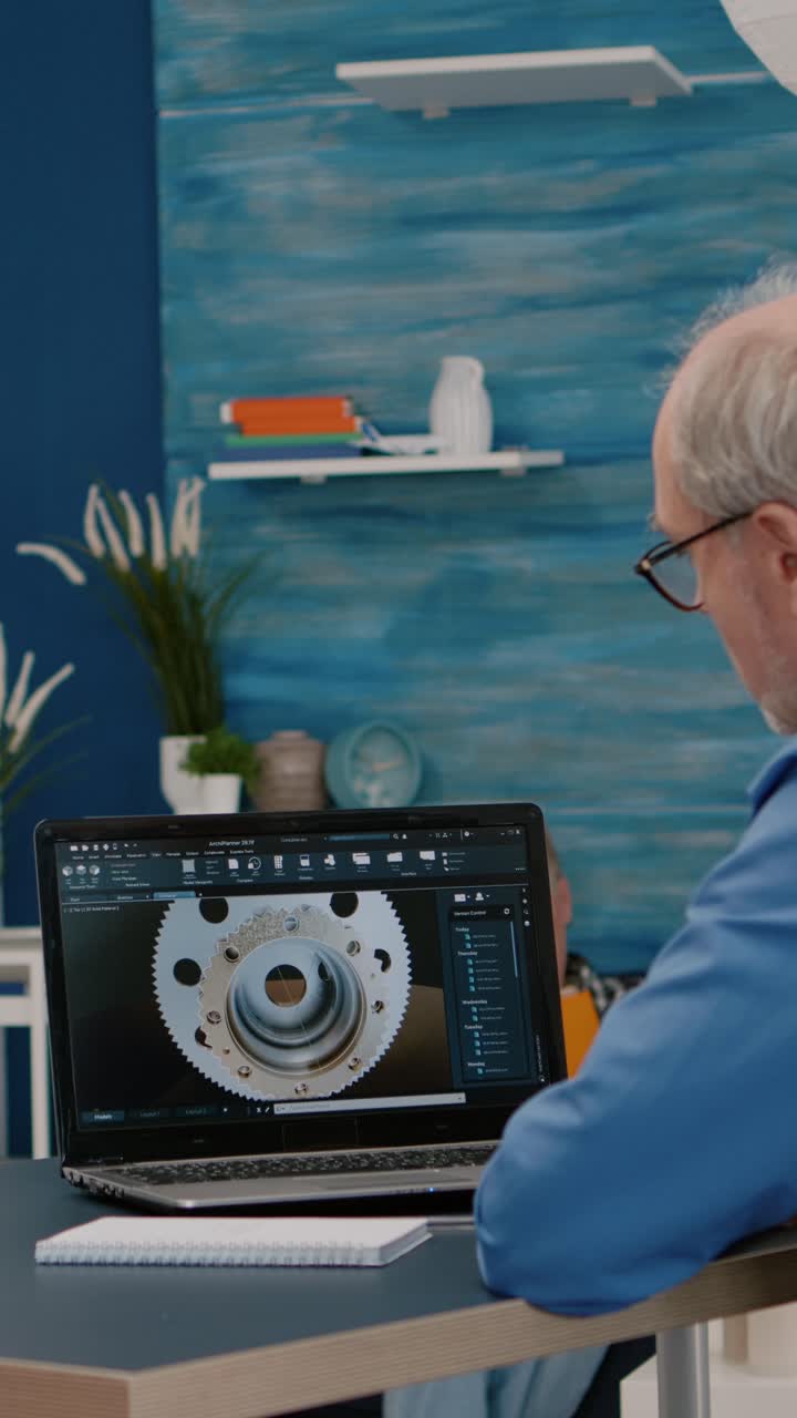 Vertical video: Senior man architect working on modern cad program analysing gears design