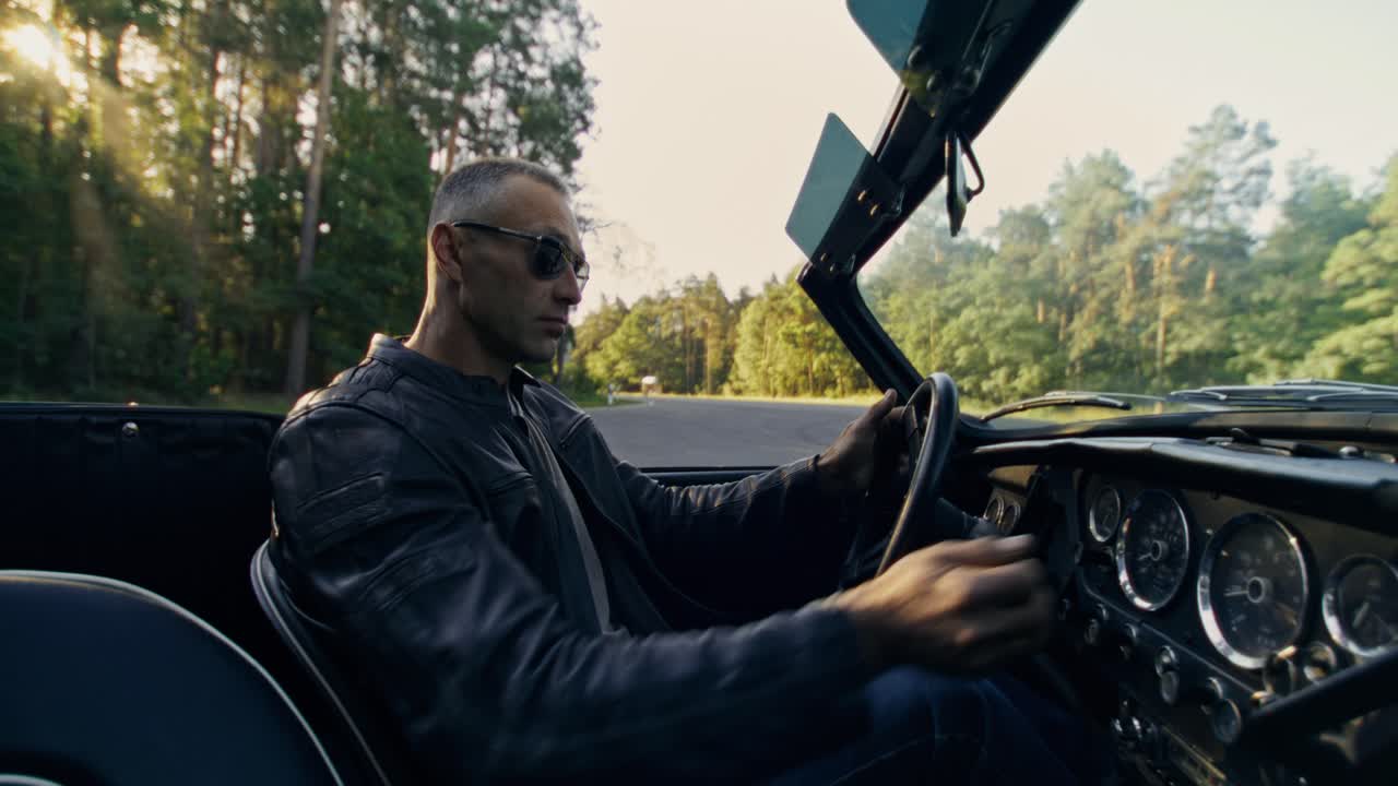 Man driving a convertible car on a road