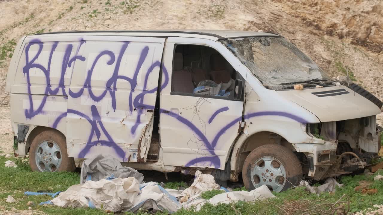 furgoneta vieja, graffiti rociado y destruido en la ladera de la montaña