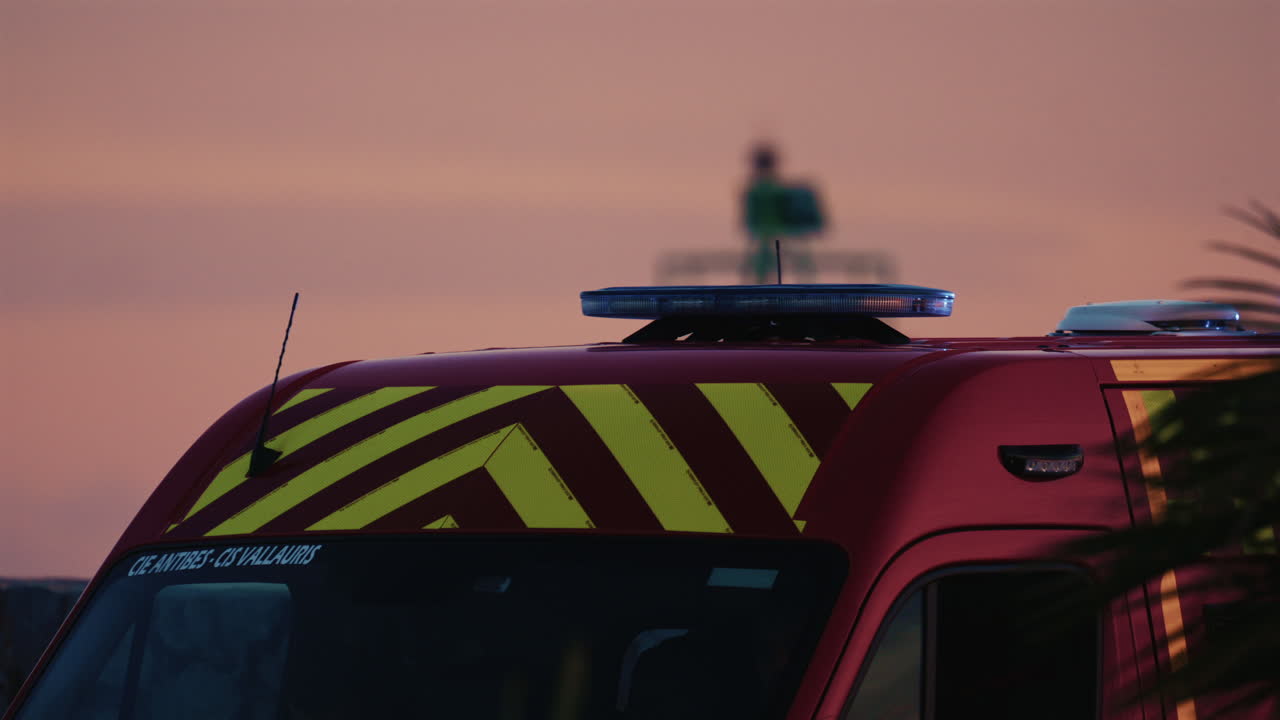 Vista laterale di un'ambulanza rossa che attraversa Antibes al crepuscolo
