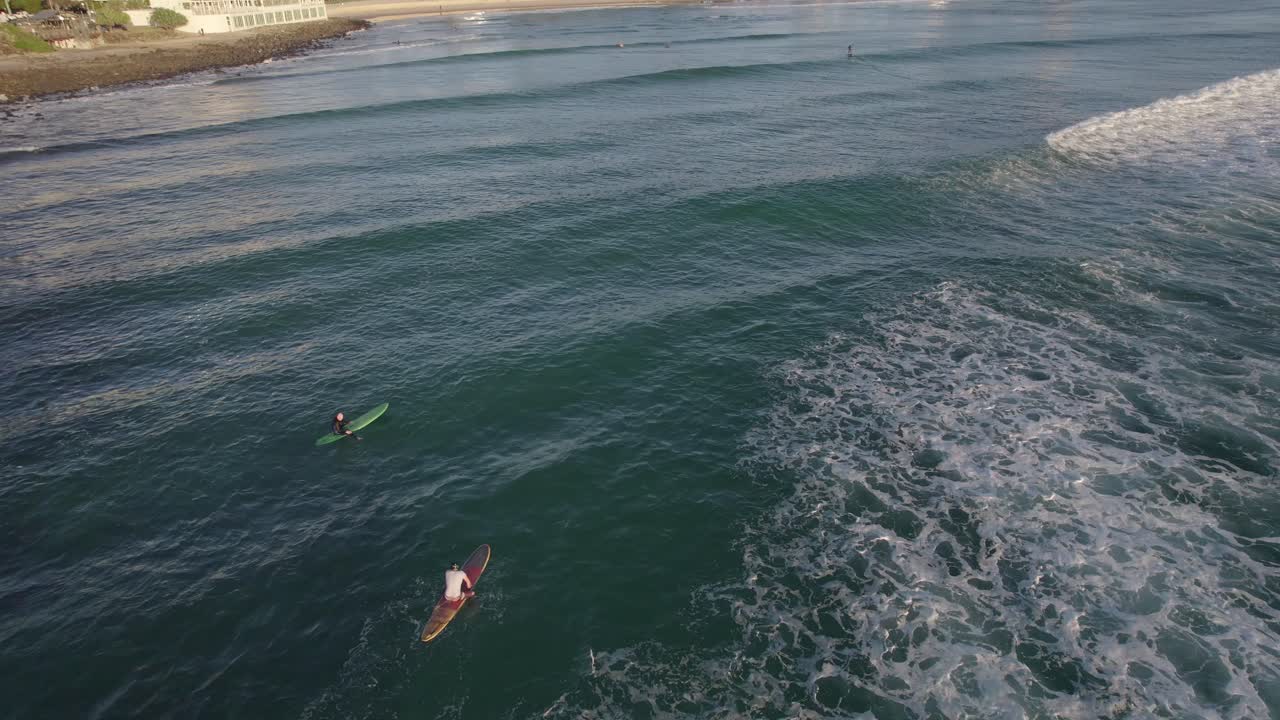 surfistas en la playa de burleigh en queensland, australia - toma aérea de un dron