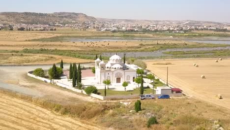 drone flying towards beautiful white church with stunning lake background, larnaca city, cyprus