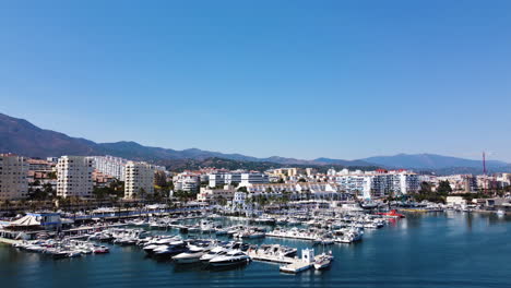 a drone pulls back for the estepona skyline overlooking the harbor waters