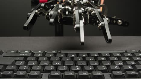 robot hand typing on a keyboard