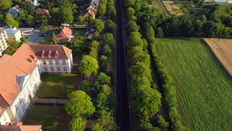 Subway-Tracks-In-Front-Of-The-Geheimes-Staatsarchiv-Preußischer-Kulturbesitz-Tranquil-Aerial-View-Flight-Tilt-Down-Drone-Above-Footagef-Domäne-Dahlem-Berlin,-Golden-Hour-Summer-2022-By-Philipp-Marnitz