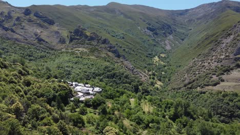 Volando-Hacia-Un-Pequeño-Pueblo-De-Piedra-Rodeado-De-Montañas