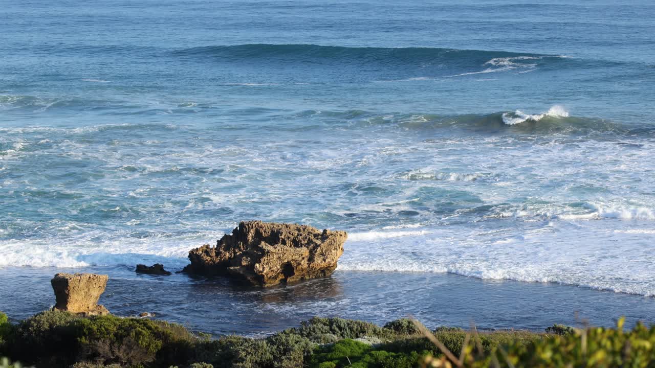 Le onde che si schiantano contro le rocce al tramonto