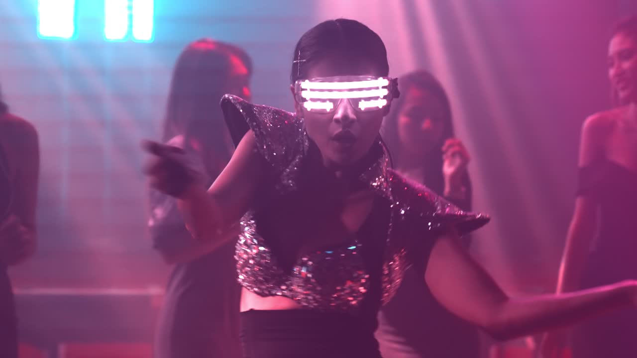 grupo de personas bailando en un club nocturno de discoteca al ritmo de la música de dj en el escenario