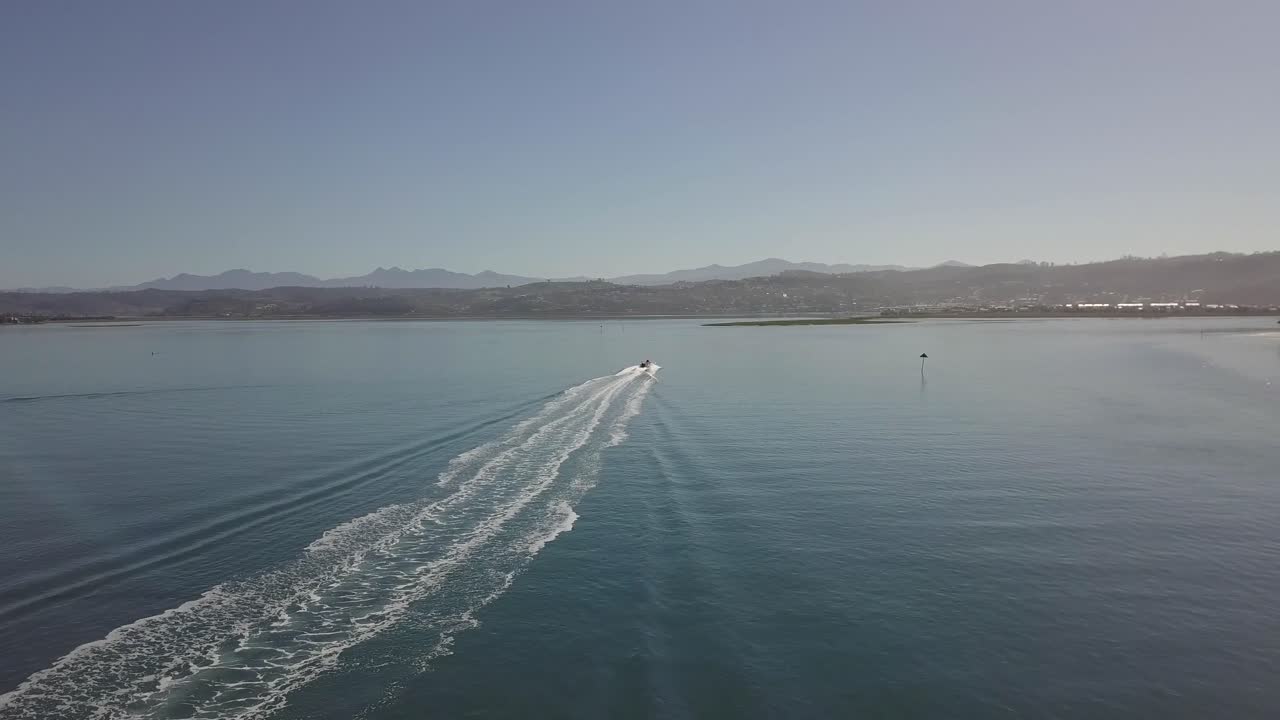 siguiendo desde el aire mientras el barco de motor da la vuelta en la laguna de knysna, sudáfrica