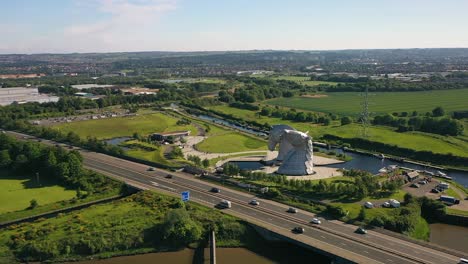 Toma-Aérea-Volando-Hacia-El-Famoso-Monumento-Escocés,-Los-Kelpies-Junto-Al-Canal-En-Falkirk.