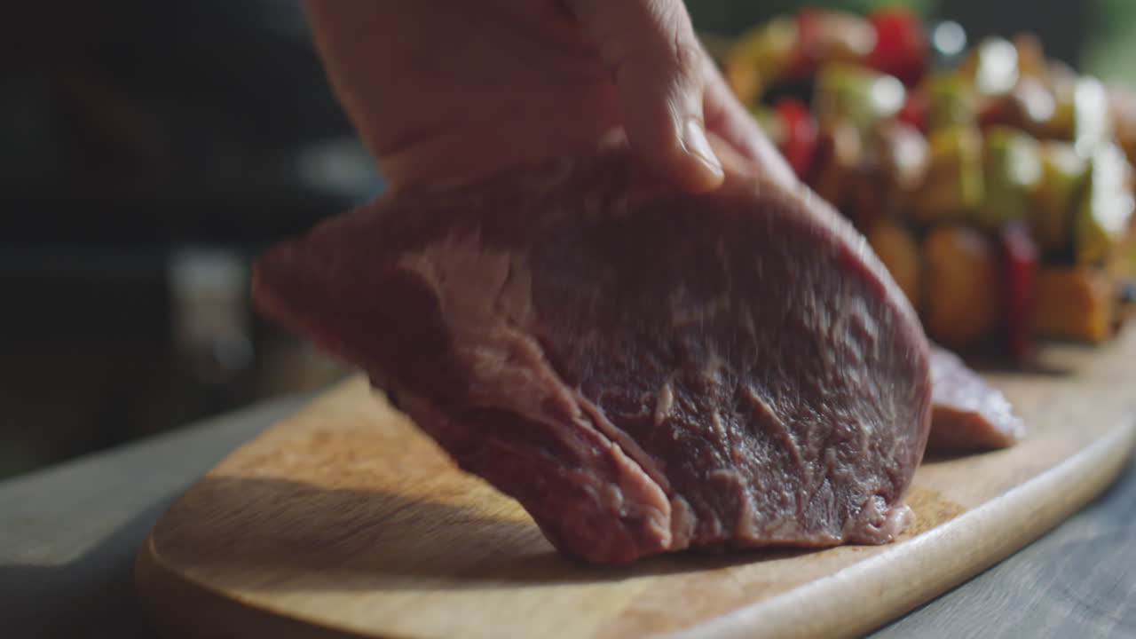 Placing Beefsteaks on Wooden Board