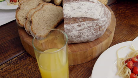 table set for dinner with spaghetti and bread