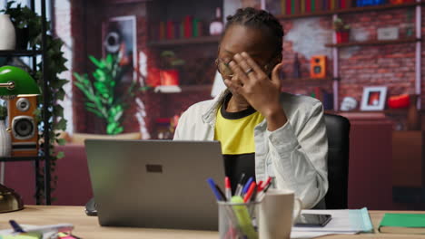tired woman in living room office sighing, overworked by tasks