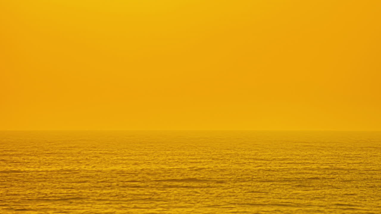 거대한 태양이 지는 안개 낀 바다 위에 황금빛 일몰 하늘