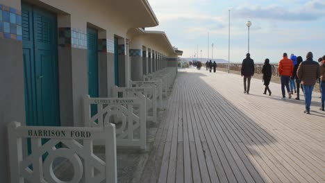 famous normandy seaside bathing cabins and wooden promenade on a sunny day in deauville, france