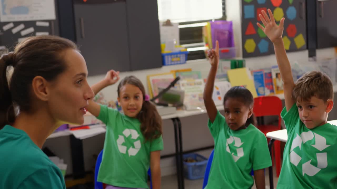 vista lateral de una maestra caucásica que enseña a los escolares sobre energía verde y reciclaje en la clase