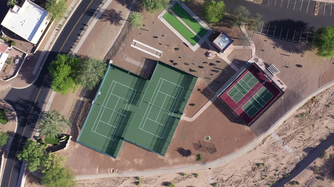 aéreo de arriba hacia abajo dando vueltas y elevándose sobre canchas de tenis vacías