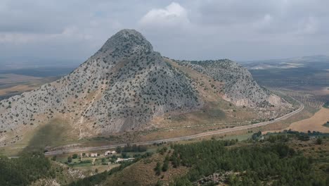 aerial views of a mountain next to a dense forest