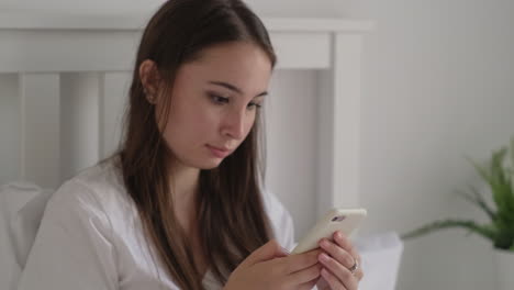 mujer joven usando teléfono inteligente en la cama