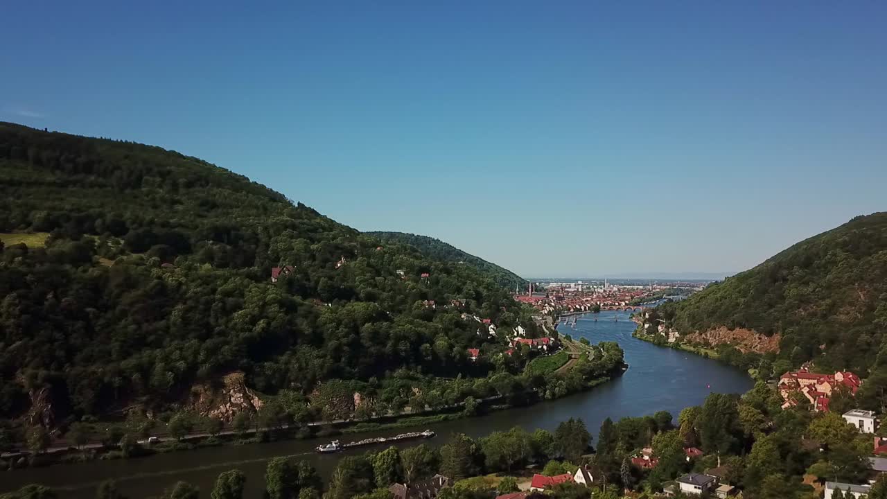 Lenta panoramica da destra a sinistra su un fiume che scorre tra montagne e attraverso una città, Heidelberg, Germania.