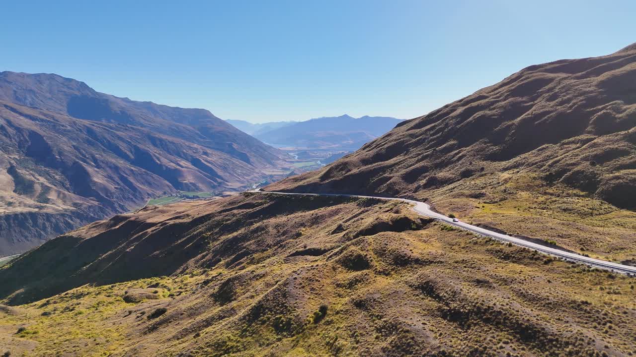4K drone captures the Crown Range Road, the highest road in New Zealand. Winding alpine roads, mountains, and valleys create a stunning aerial view of the South Island landscape