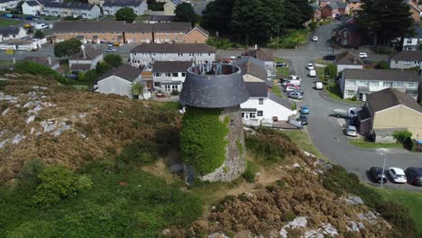 Llangefni-Windmühle,-Mit-Efeu-Bedeckter-Hügel,-Wahrzeichen,-Mobilfunkmast,-Luftaufnahme,-Die-Oben-Umkreist