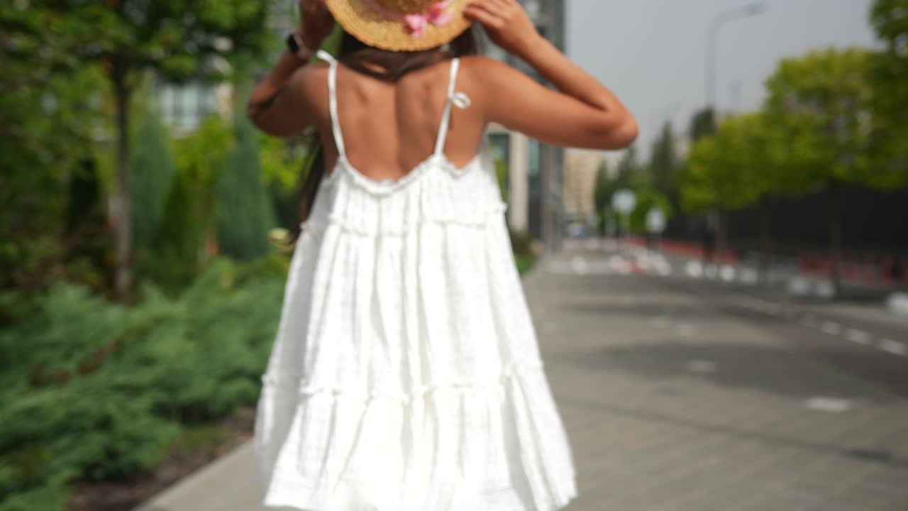 하 드레스 와  모자 를 입은 여자 가 야외 에서 고 있다