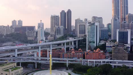 aerial pan aross chongqing city china skyline as golden hour light glimmers on skyscrapers