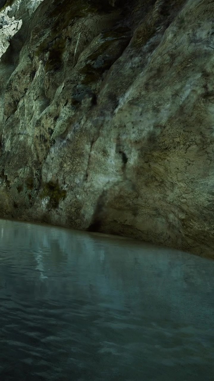 Água flui por uma parede rochosa em um local tranquilo perto de um leito de rio na natureza