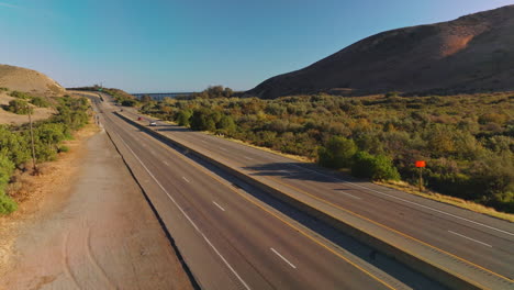 two-ways roads going through the humpy mountainous territory. transport moving by the highways at the backdrop of blue skies.
