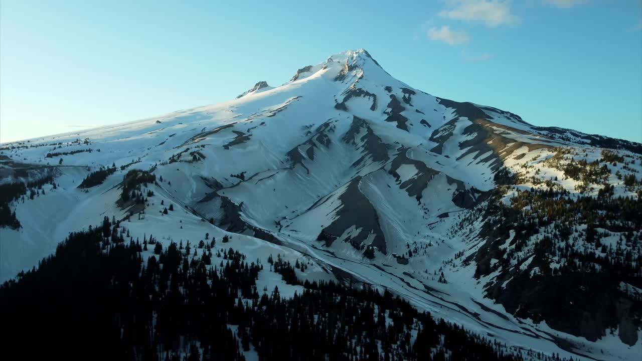 US, Oregon, Mt Hood, White River, 2025-04-22 - Drone view of Mt Hood at sunset over the White River in spring, with snow still covering the mountain and creek and trees