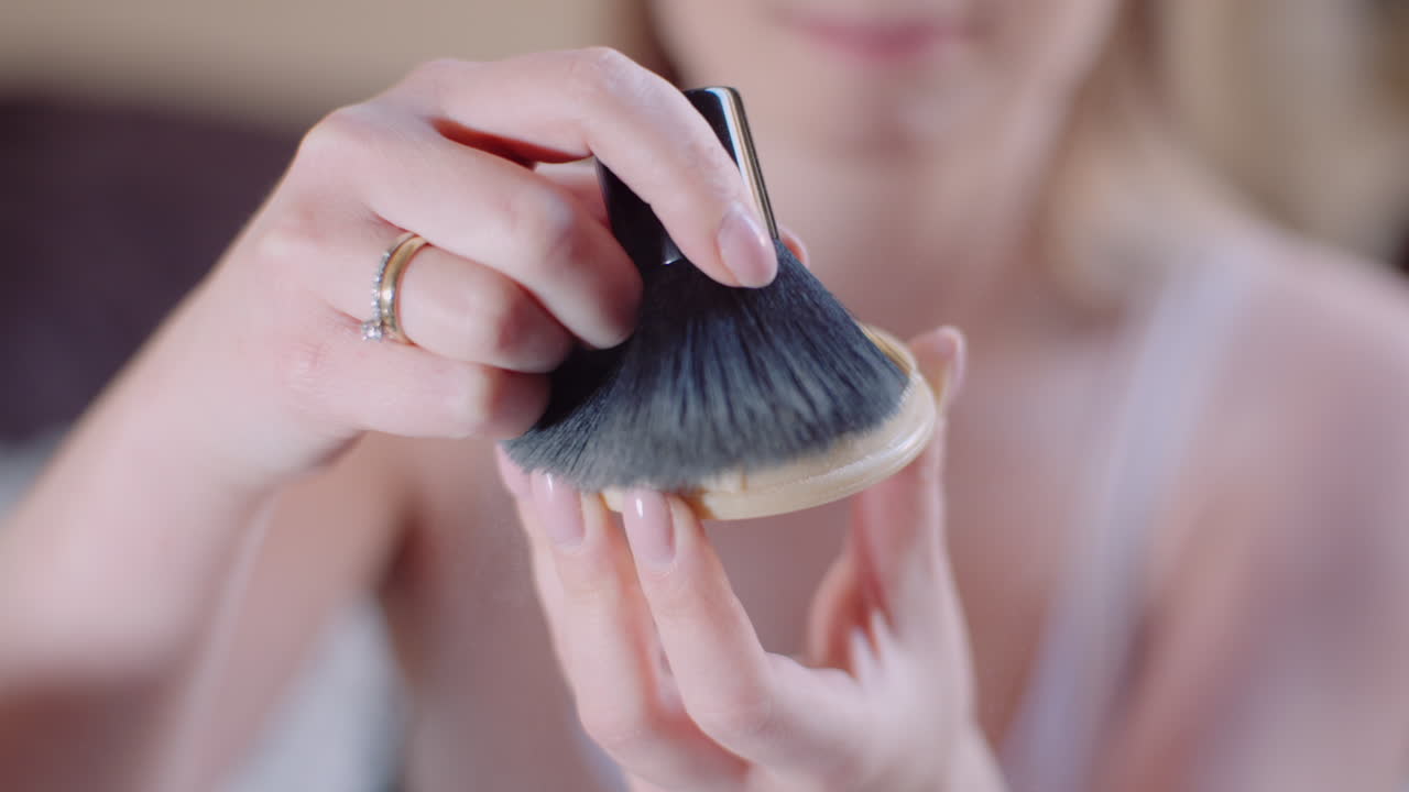 mujer atractiva haciendo maquillaje aplicando polvo