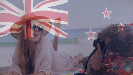 new zealand flag animation over people relaxing on beach