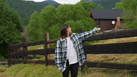 mujer explorando las montañas cerca de una cabaña de madera