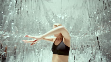 woman performing experimental dance against silver background