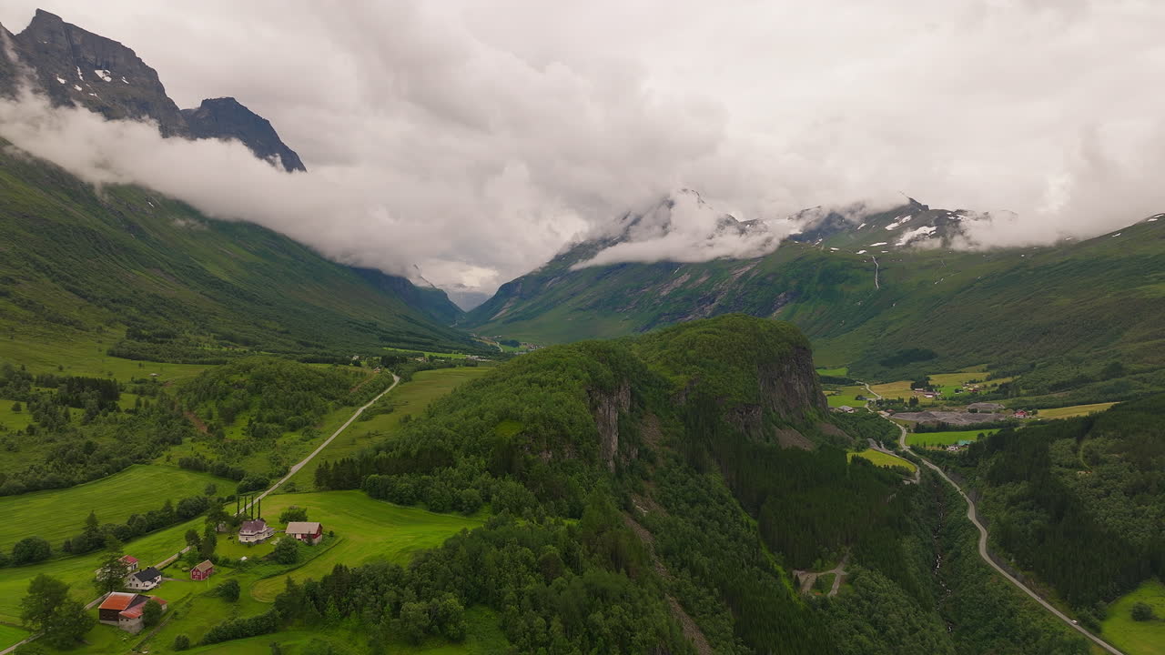 un panorama aéreo impresionante de un valle verde, nubes bajas