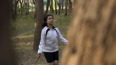 athletic beautiful woman exercises with jump, skipping rope in the forest