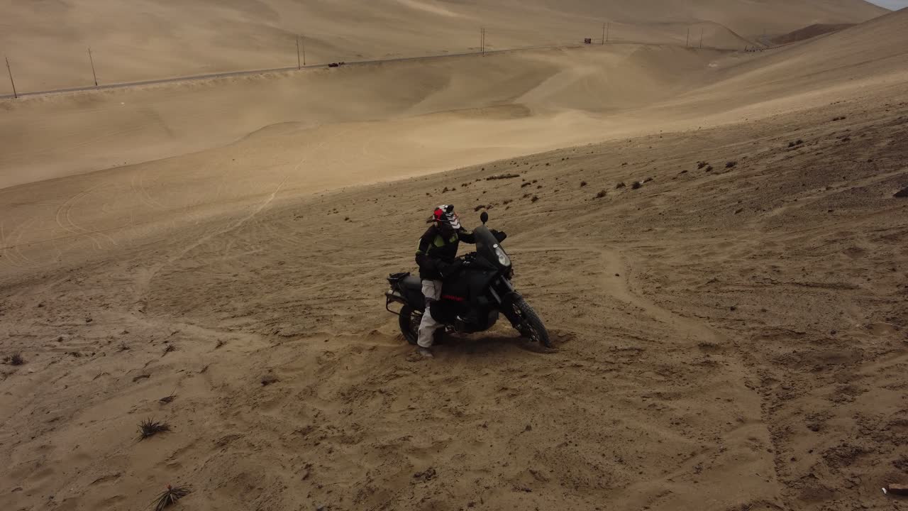 Moto bloccata nella sabbia in cima a una ripida collina o duna nel deserto